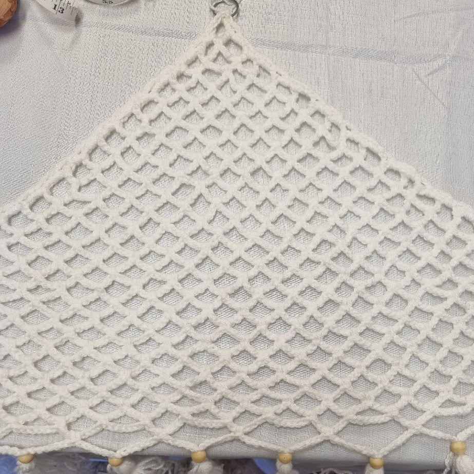 Macrame wall hanging with tassels on a tiled floor