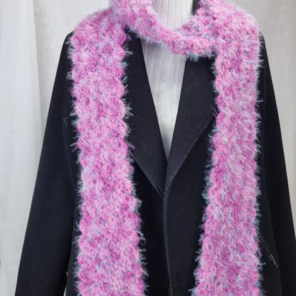 Pink knitted scarf draped over a black coat on a white background