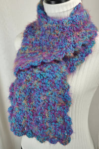 Multicolored knitted scarf on a mannequin with a plain background