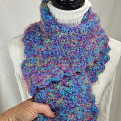 Multicolored knitted scarf on a mannequin with a plain background
